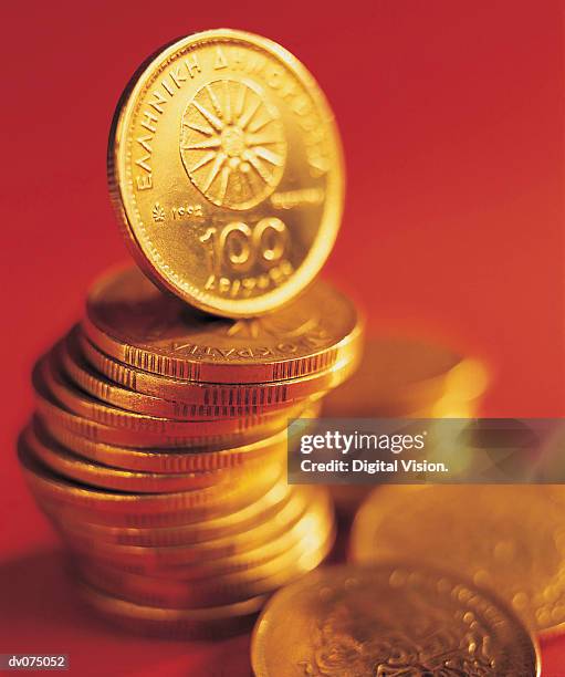 pile of drachmas on red background - ehemalige griechische währung stock-fotos und bilder