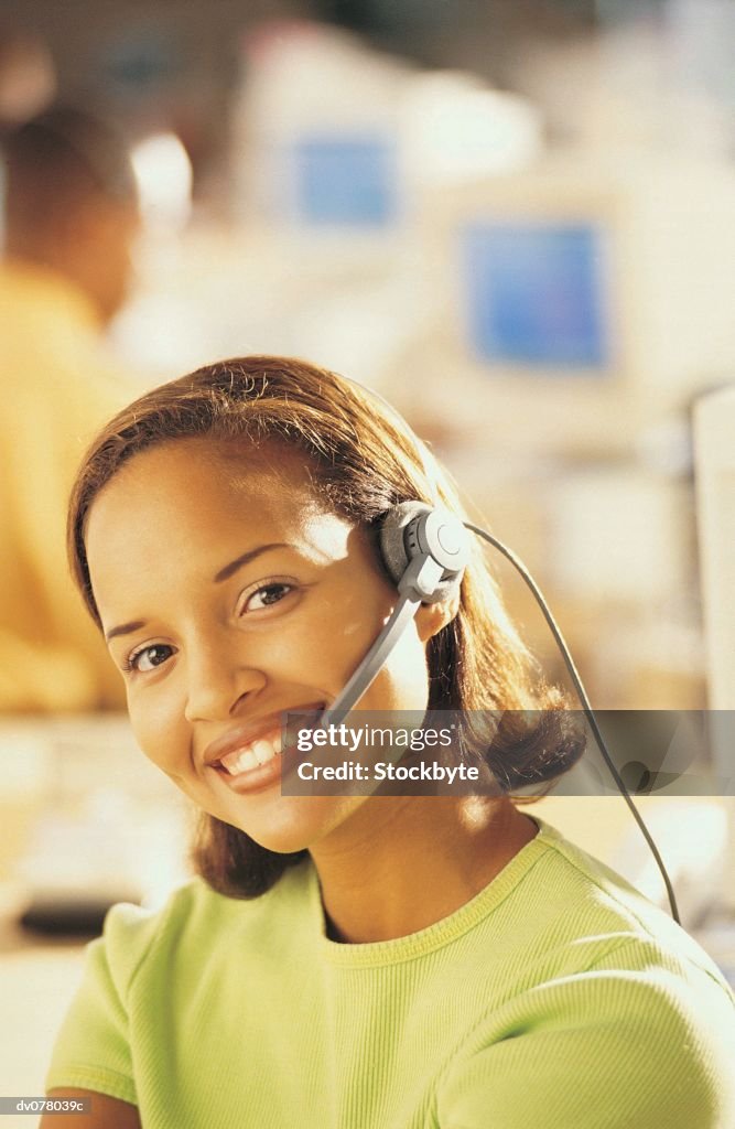 Woman wearing telephone headset, smiling