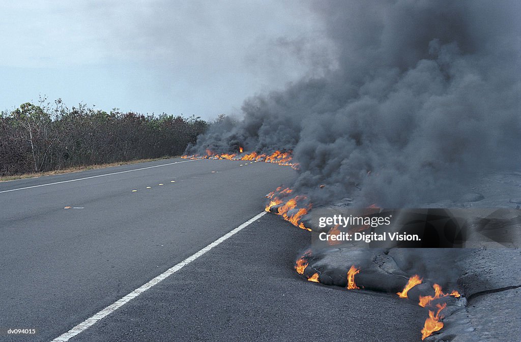 Flaming Lava Flow Moving Across a Road