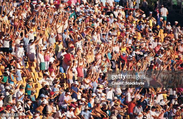enthusiastic crowd cheering and doing the wave - enthusiastic crowd cheering and doing the wave stock pictures, royalty-free photos & images