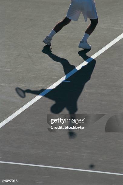 tennis player at baseline, about to serve ball - baseline stock pictures, royalty-free photos & images