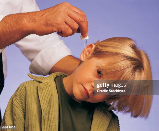 boy having eardrops administered - administered stock pictures, royalty-free photos & images