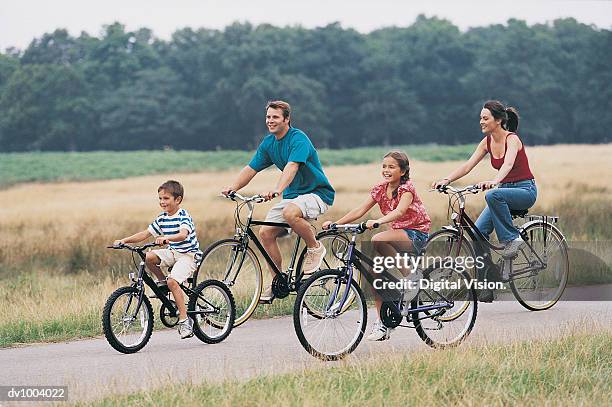 family cycling on a country road - two kids with cycle stock-fotos und bilder