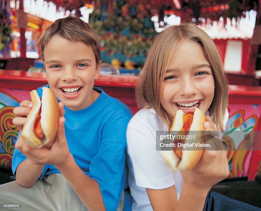 Portrait of a Brother and Sister Holding Hot Dogs