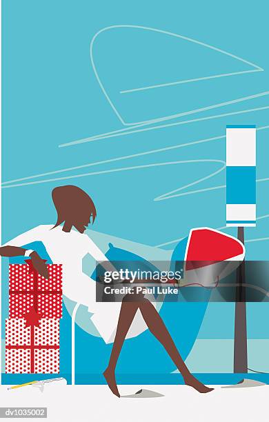 woman sitting in an armchair using her computer to shop on the internet - luke stock-grafiken, -clipart, -cartoons und -symbole
