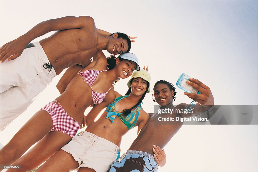 Teenage Men and Women, One Man Holding a Camera Taking a Photograph