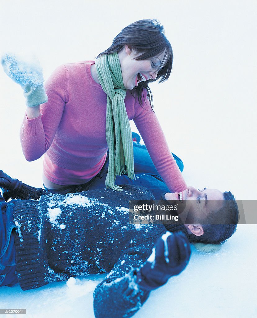 Couple in the Snow Throwing Snowballs