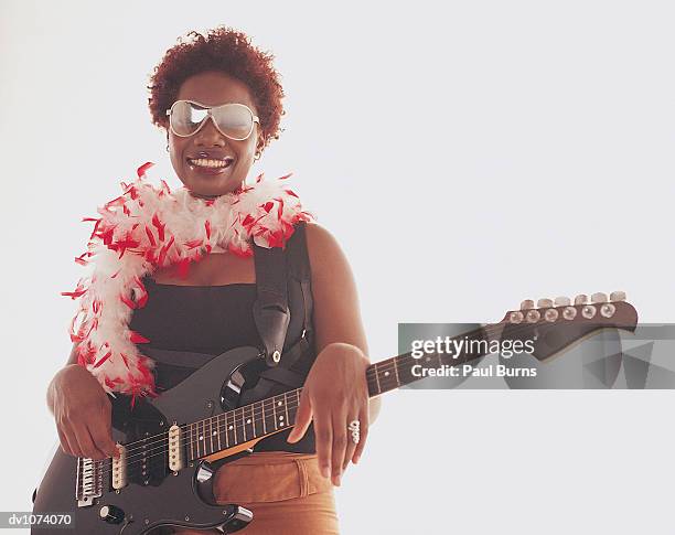 portrait of a female musician with an electric guitar and a feather boa - 7894 stock pictures, royalty-free photos & images