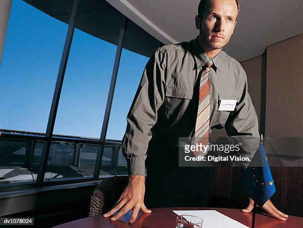 portrait of a businessman standing at a conference table by a european union flag - key speakers at the international economic forum of the americas conference of montreal stockfoto's en -beelden