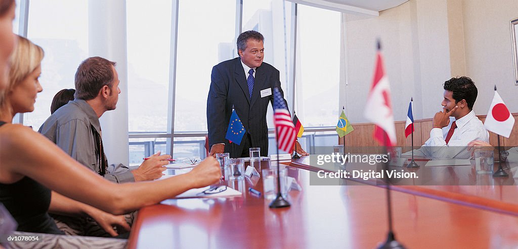 Businessman Giving a Presentation in a Conference Room to Other Business Executives