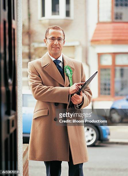 portrait of a male politician holding a clipboard and standing in a street - clipboard and glasses imagens e fotografias de stock