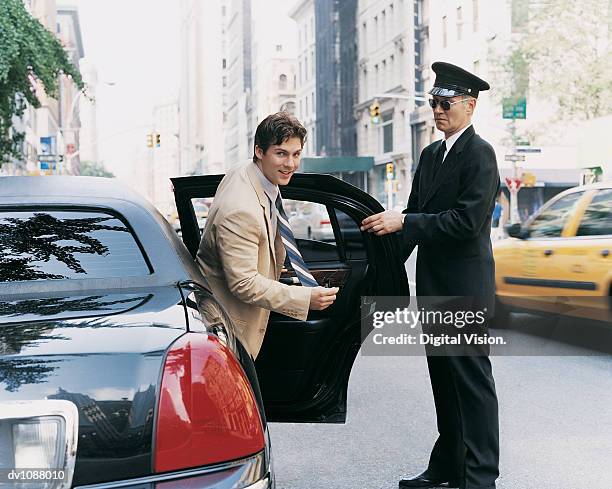 chauffer opening the door of car for a young ceo in manhattan, new york, usa - chauffeur stock pictures, royalty-free photos & images