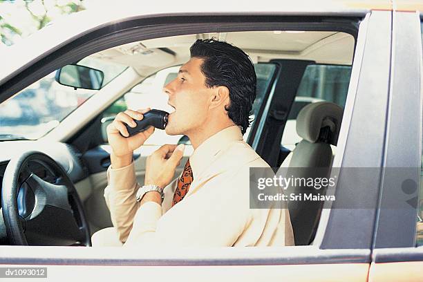 businessman using an electric razor in the front seat of his car - electric razor stock pictures, royalty-free photos & images