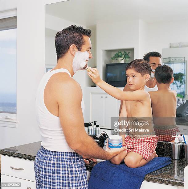 son helping his father shave in the bathroom - shaving brush stock pictures, royalty-free photos & images