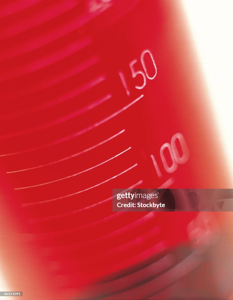 Graduated cylinder filled with red liquid