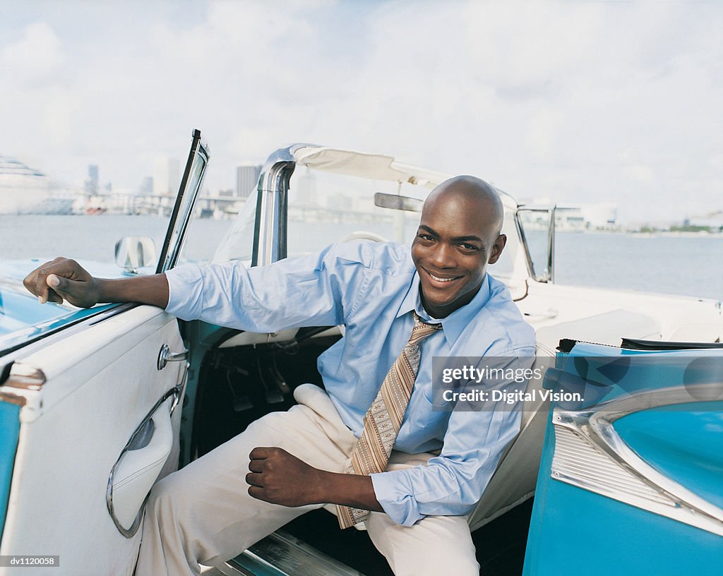 Portrait of a Businessman Sitting in a 1950's Style Car