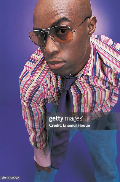 portrait of a young man wearing sunglasses with his hand on his knee - hand on knee ストックフォトと画像