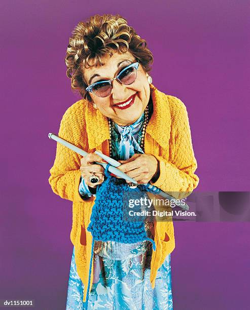 portrait of an old woman knitting - alleen seniore vrouwen stockfoto's en -beelden