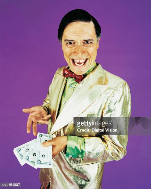 portrait of a game show host holding bundles of banknotes - apresentador de programa de jogo - fotografias e filmes do acervo