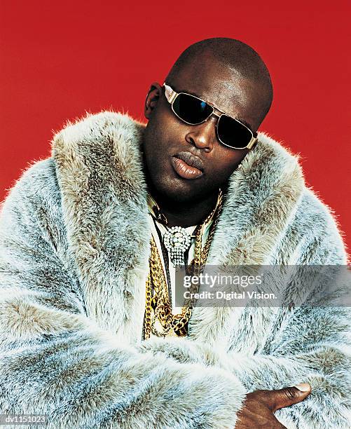 portrait of a male rapper wearing a fur coat, gold chains and sunglasses - bling bling imagens e fotografias de stock