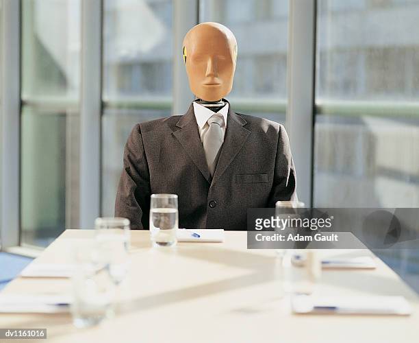 crash test dummy sitting behind a desk in a meeting room - crash test dummies stock-fotos und bilder