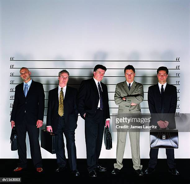 group of serious businessmen standing holding briefcases in a police line-up and a man with his arms crossed - lineup fotografías e imágenes de stock