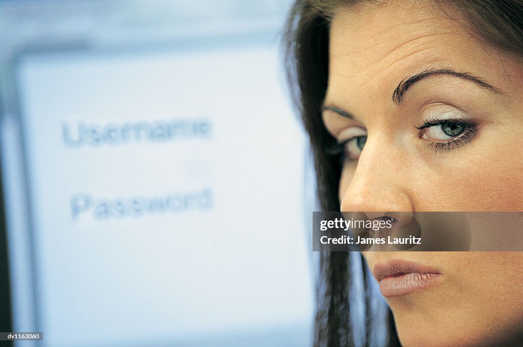 Portrait of a Suspicious Businesswoman and Password Security Text on a Computer Screen