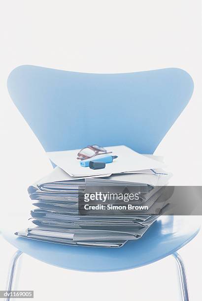 stack of folders on a chair with spectacles and a felt tip pen on top - felt tip pen stock-fotos und bilder