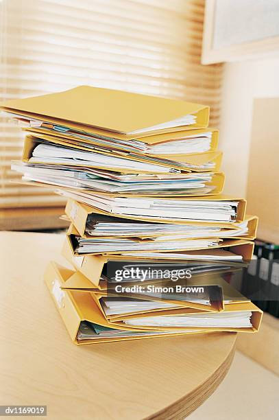 stack of ring binders on a table in an office - binders stockfoto's en -beelden