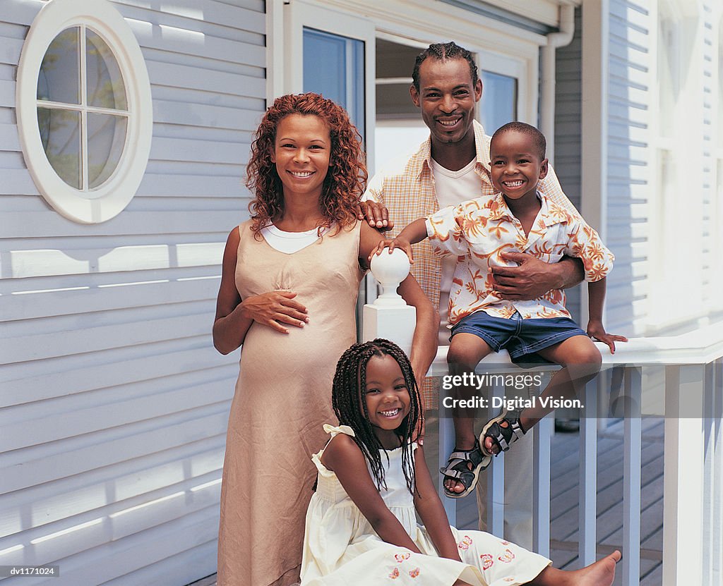 Portrait of a Family Outdoors on a Porch and the Mother Pregnant