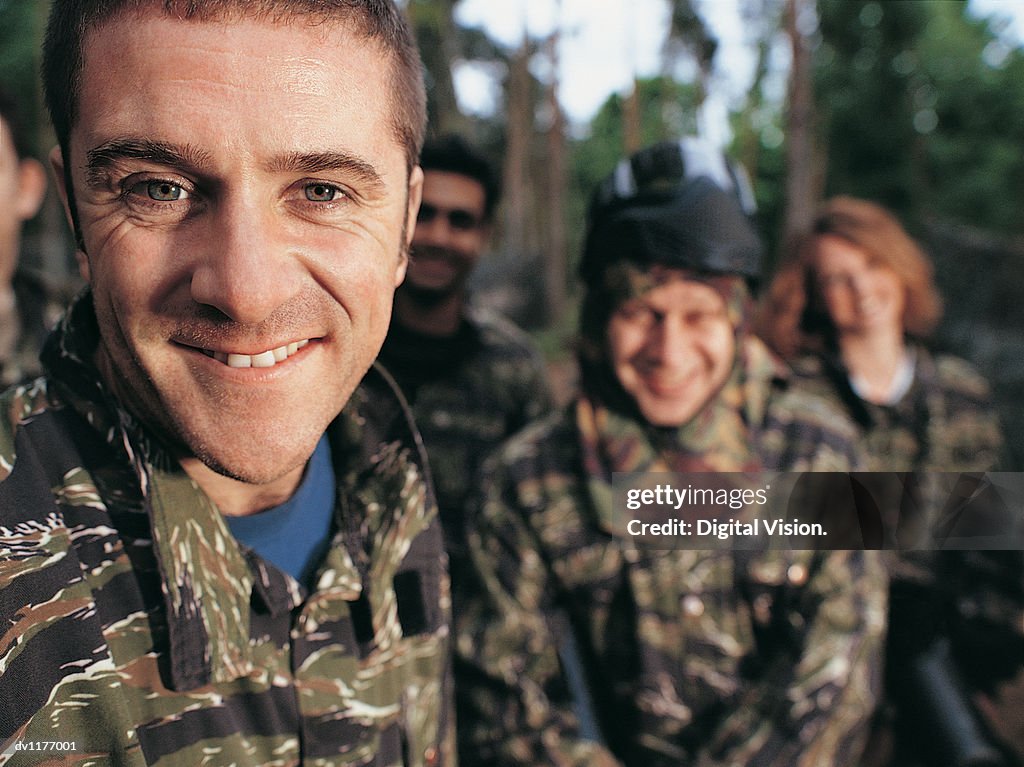 Portrait of a Man Paintballing With Friends Dressed in Camouflage Clothing