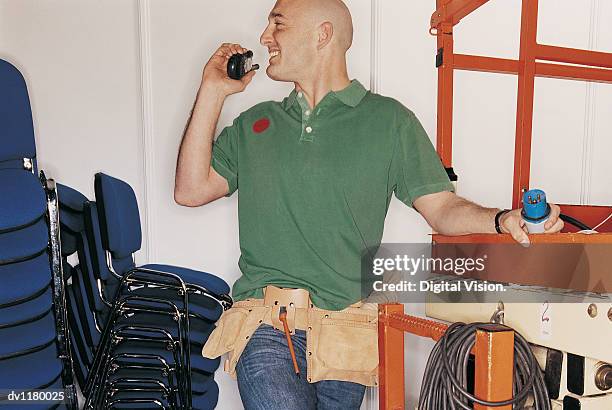 workman using a walkie talkie at a business conference and holding an electric plug - wired business conference stock pictures, royalty-free photos & images