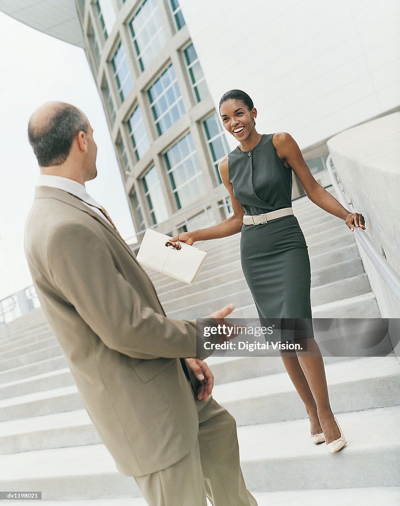 Businesswoman and a Businessman Standing on a Stairway