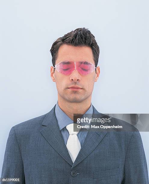 portrait of a young businessman wearing pink sunglasses with his eyes closed - rose tinted glasses stock pictures, royalty-free photos & images