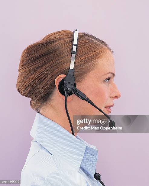 side view of a young businesswoman wearing a headset - ojos grises fotografías e imágenes de stock