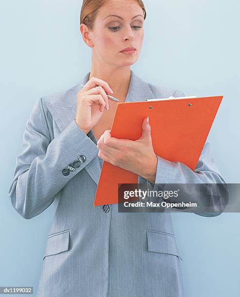 businesswoman holding a clipboard and a ballpoint pen - ojos grises fotografías e imágenes de stock