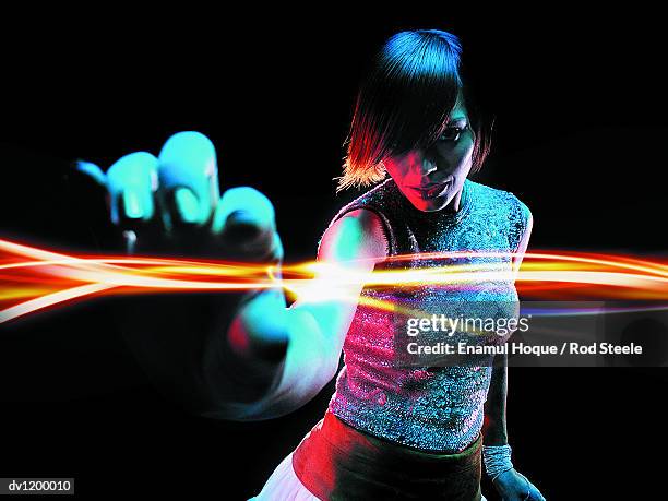 portrait of a young woman reaching out to touch light - gel effect lighting 個照片及圖片檔
