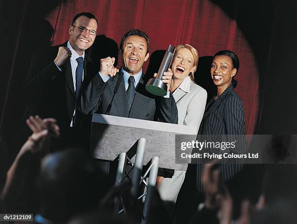 happy business people receiving a prize at an award ceremony - receiving trophy stock pictures, royalty-free photos & images