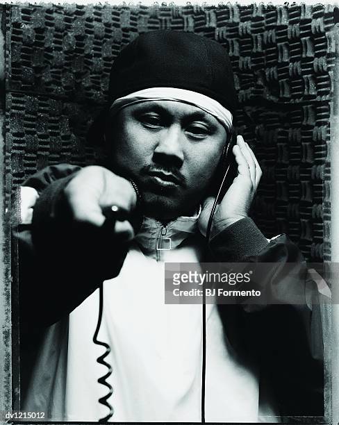 portrait of a rapper wearing headphones in a recording studio - tracksuit jacket bildbanksfoton och bilder