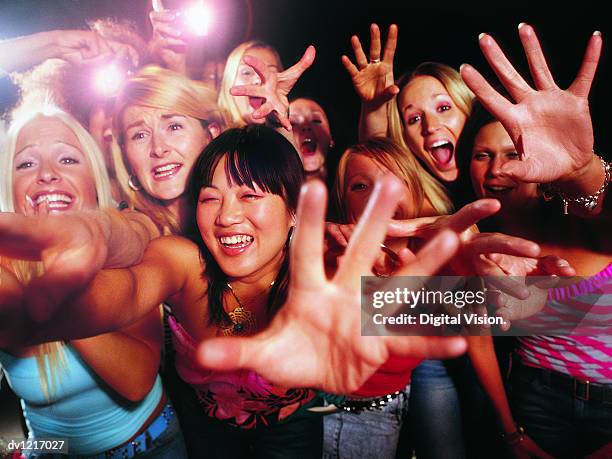 crowd of young, female fans stretching out their hands and shouting - desire stock photos et images de collection