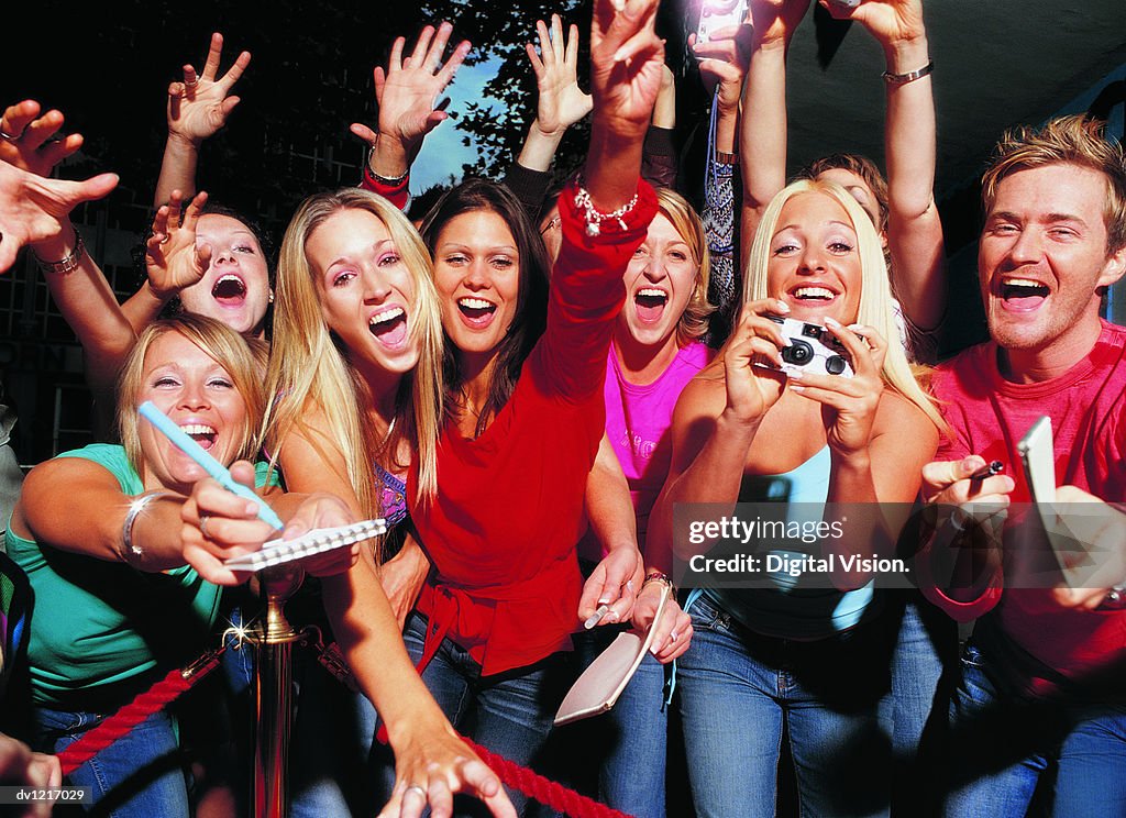 Crowd of Young Fans Stretching Out Their Hands and Shouting