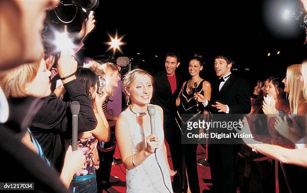tv presenter, actors and a group of fans at a movie premiere - prima cinematografica foto e immagini stock