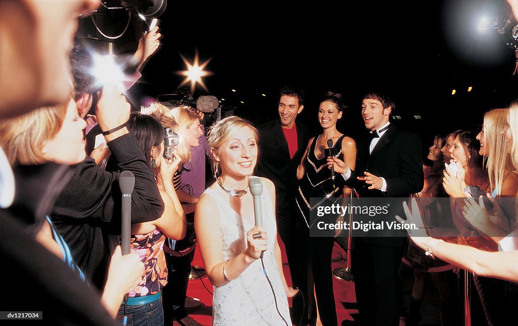Tv Presenter, Actors and a Group of Fans at a Movie Premiere