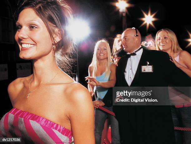 young actress standing in front of a bodyguard with her fans - in front of camera stock pictures, royalty-free photos & images