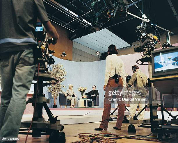 tv presenters in a studio with a producer and cameramen - tournage photos et images de collection