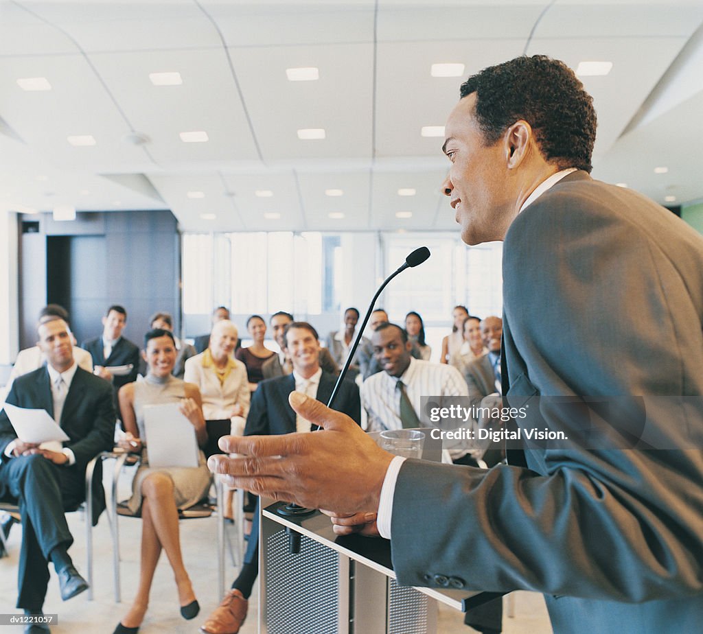 CEO Giving a Presentation to a Group of Business People from a Podium in a Conference Room