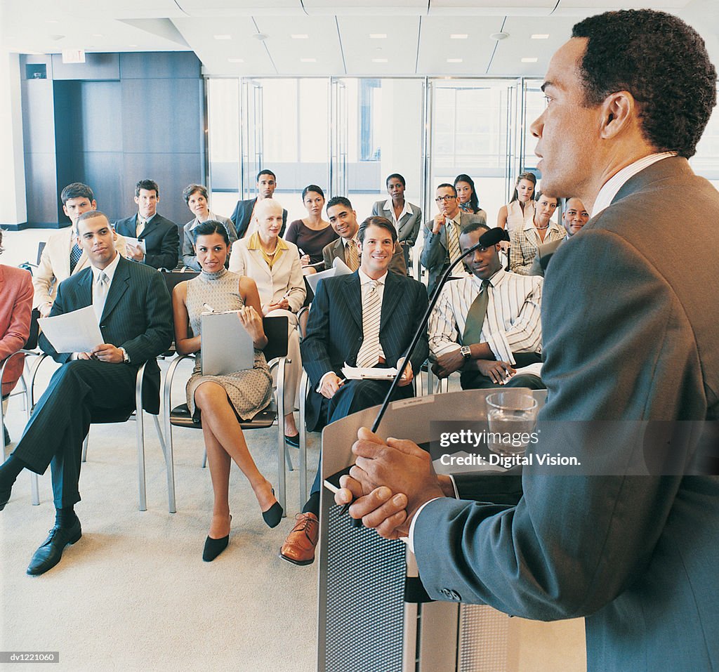 CEO Giving a Presentation to a Group of Business People from a Podium in a Conference Room