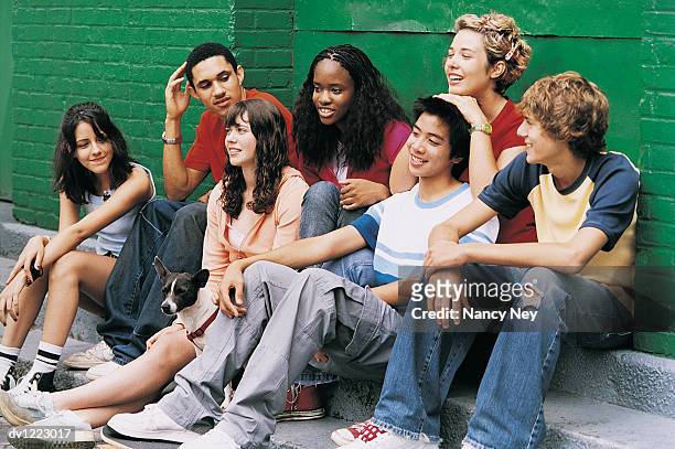 teenage boys and girls sitting by a wall - nancy green fotografías e imágenes de stock