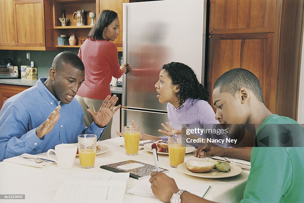 Family in Kitchen at Breakfast With Father and Daughter Arguing