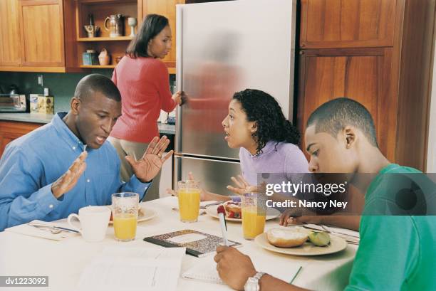 family in kitchen at breakfast with father and daughter arguing - angry parent mealtime stock pictures, royalty-free photos & images